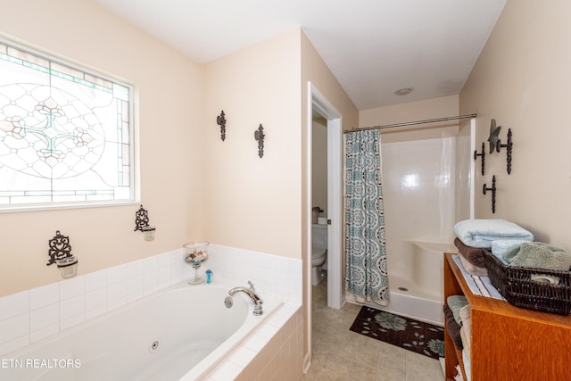 full bathroom featuring toilet, a whirlpool tub, tile patterned flooring, and a stall shower