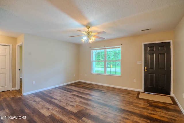 entrance foyer featuring dark wood-type flooring, visible vents, a ceiling fan, and a textured ceiling