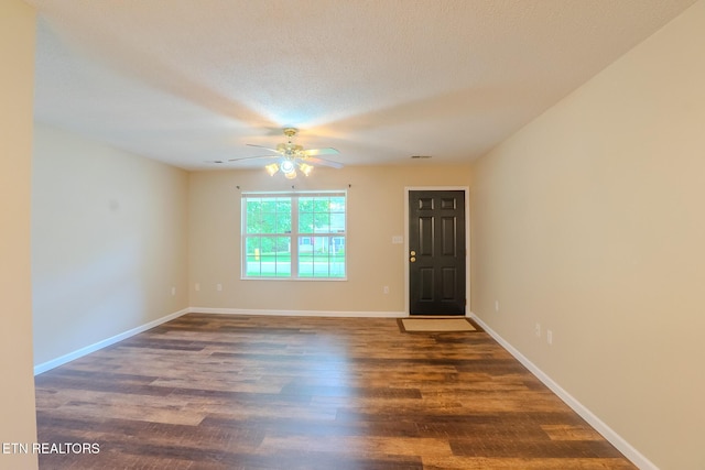 spare room featuring baseboards, wood finished floors, and ceiling fan