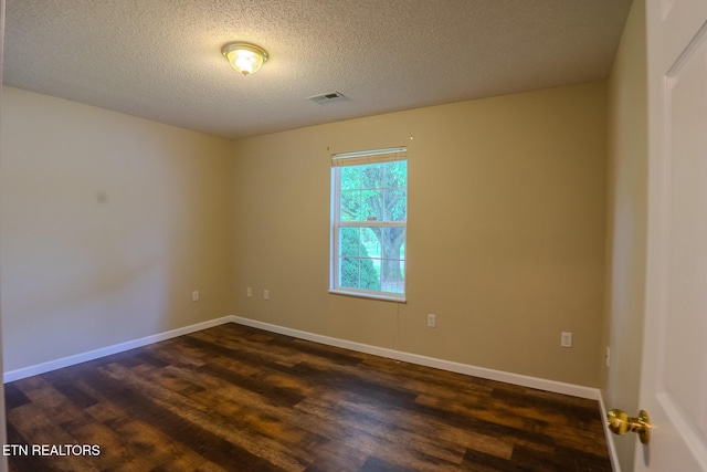 unfurnished room with dark wood-style floors, a textured ceiling, visible vents, and baseboards