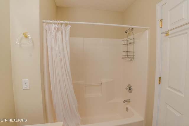 bathroom with shower / tub combo with curtain and a textured ceiling