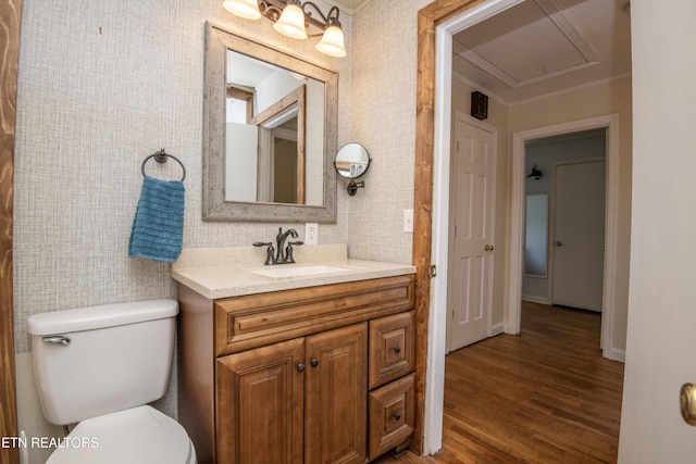 bathroom with crown molding, vanity, wood finished floors, toilet, and baseboards