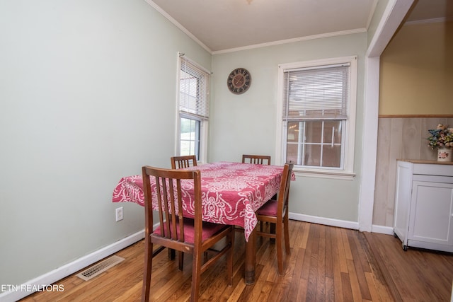 dining area featuring crown molding, baseboards, wood-type flooring, and visible vents