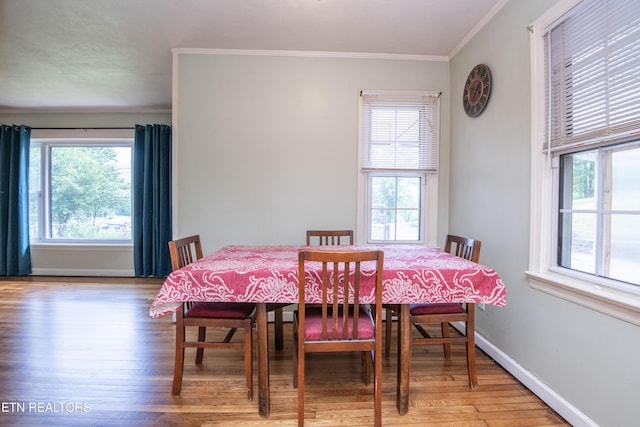 dining space with crown molding, plenty of natural light, and light wood-type flooring