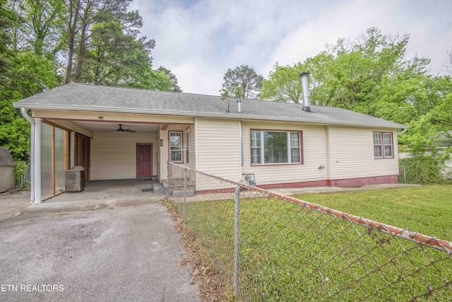 ranch-style home featuring driveway, a ceiling fan, a front yard, fence, and an attached carport