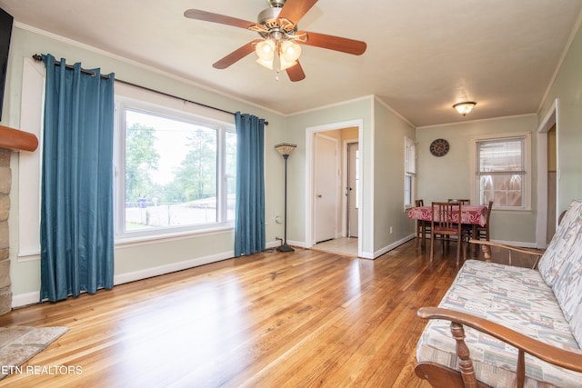 sitting room with crown molding, baseboards, ceiling fan, and wood finished floors