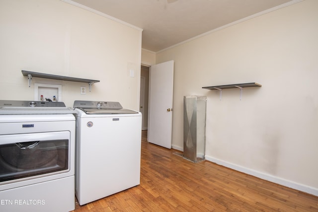laundry room with laundry area, baseboards, ornamental molding, light wood-style flooring, and washer and clothes dryer