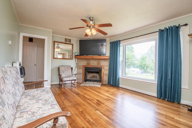 living room featuring visible vents, light wood finished floors, ceiling fan, and a fireplace