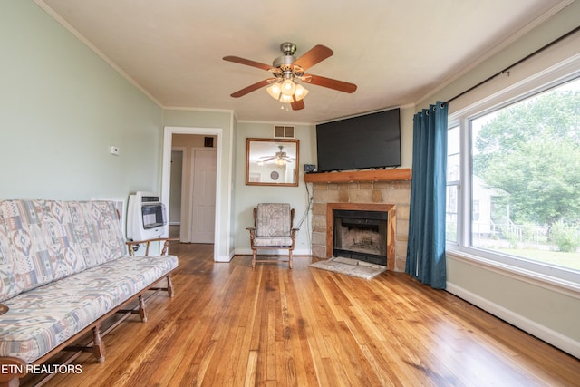 living room featuring visible vents, crown molding, heating unit, hardwood / wood-style floors, and ceiling fan