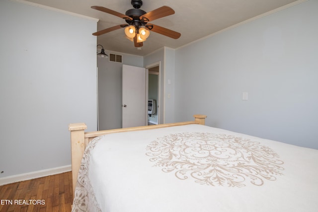 bedroom with visible vents, crown molding, wood finished floors, baseboards, and a ceiling fan