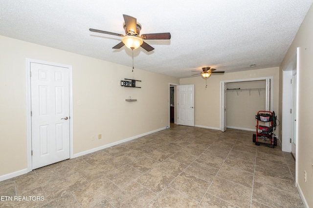 interior space featuring baseboards, a ceiling fan, and a textured ceiling