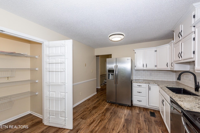 kitchen featuring a sink, white cabinets, stainless steel appliances, and dark wood-style floors