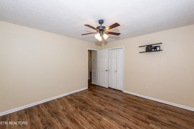 unfurnished bedroom featuring visible vents, a closet, wood finished floors, baseboards, and a textured ceiling