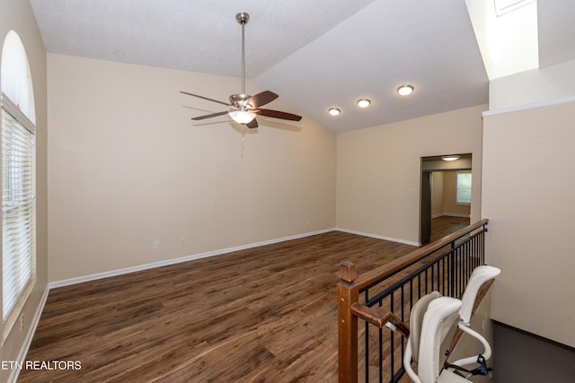 unfurnished room featuring baseboards, a ceiling fan, vaulted ceiling, and wood finished floors