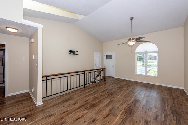 unfurnished room with baseboards, a ceiling fan, wood finished floors, and vaulted ceiling