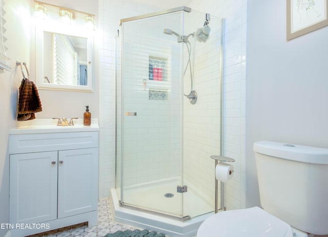 full bathroom with a shower stall, toilet, and vanity