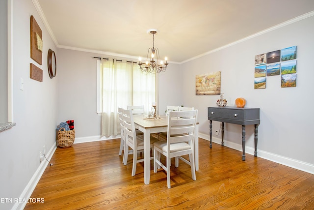 dining room featuring a chandelier, light wood-style flooring, baseboards, and ornamental molding