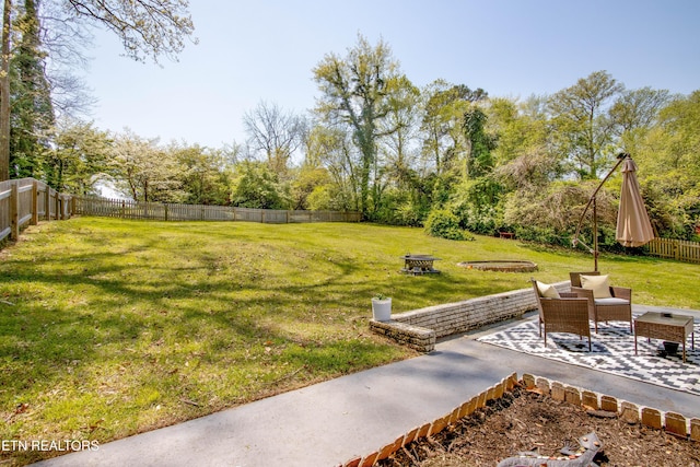 view of yard with a fenced backyard, a patio, and an outdoor fire pit