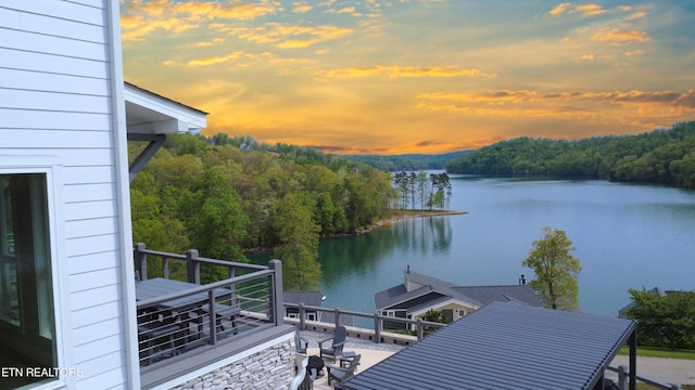 view of dock featuring a forest view and a water view