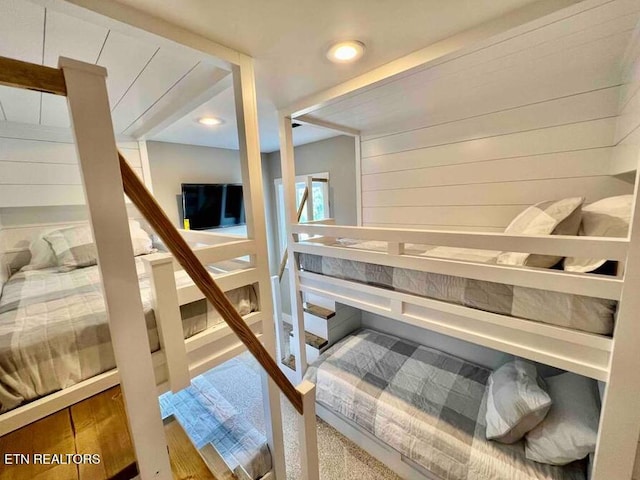 carpeted bedroom featuring wooden walls and recessed lighting