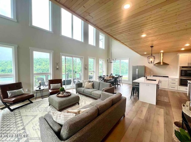 living area with recessed lighting, a high ceiling, light wood finished floors, and wooden ceiling