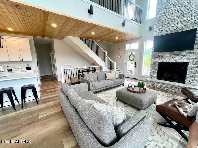 living room featuring wooden ceiling, a wealth of natural light, light wood finished floors, and a fireplace