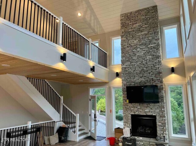living area with a fireplace, a towering ceiling, and plenty of natural light