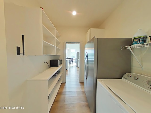 laundry room with light wood-style flooring and washer / clothes dryer