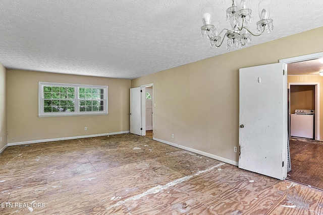 empty room featuring baseboards, washer / clothes dryer, a chandelier, and a textured ceiling