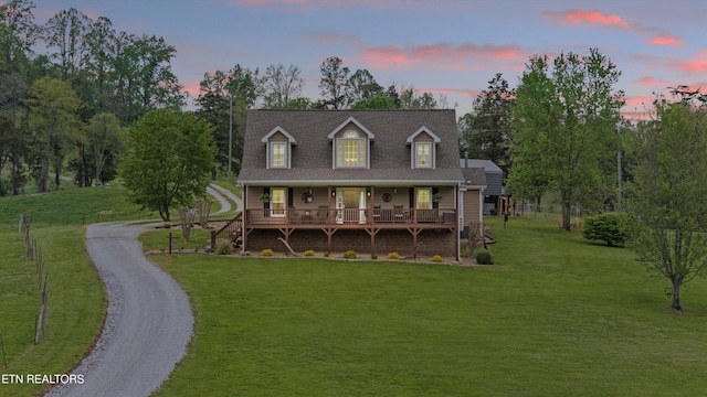 view of front of property with a porch, driveway, and a front yard