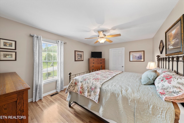 bedroom with ceiling fan, baseboards, visible vents, and light wood finished floors