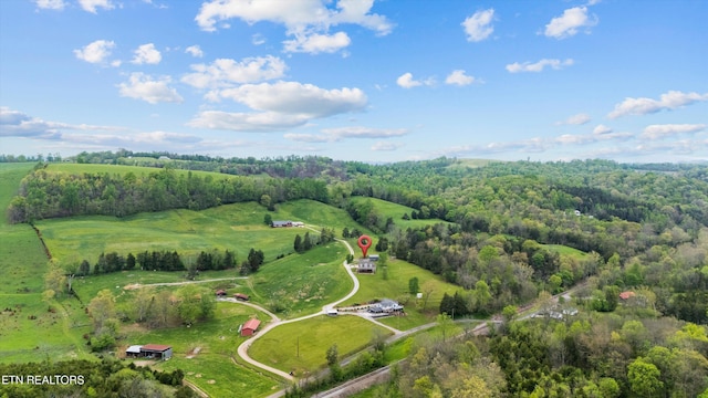 birds eye view of property with a view of trees and a rural view
