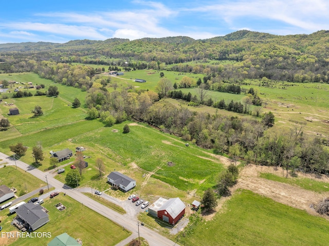 aerial view with a rural view, a view of trees, and a mountain view
