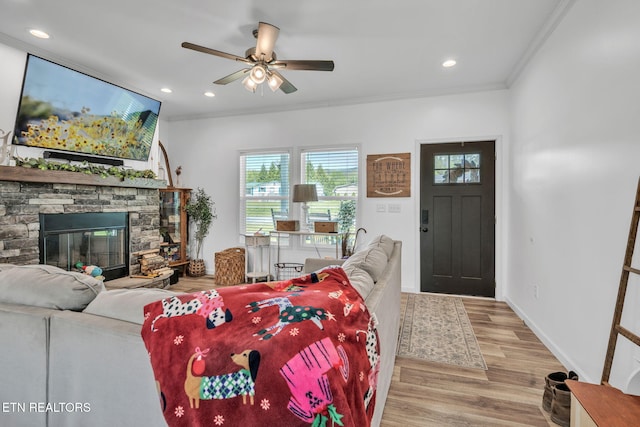 living room featuring recessed lighting, wood finished floors, a ceiling fan, ornamental molding, and a fireplace