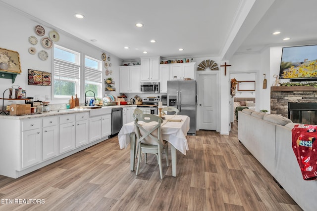 kitchen featuring appliances with stainless steel finishes, light wood-style floors, white cabinetry, and recessed lighting