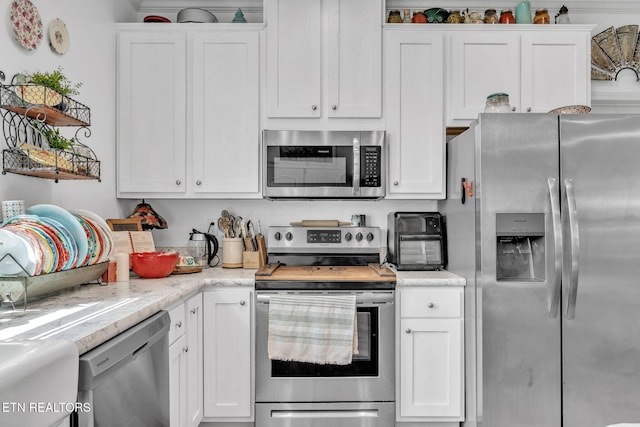 kitchen featuring white cabinets, open shelves, appliances with stainless steel finishes, and a toaster