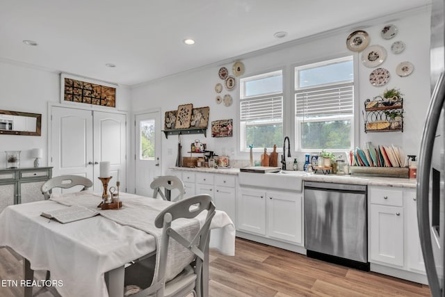 kitchen featuring dishwasher, white cabinets, and a wealth of natural light