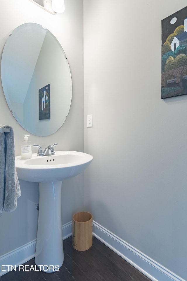 bathroom featuring a sink, wood finished floors, and baseboards