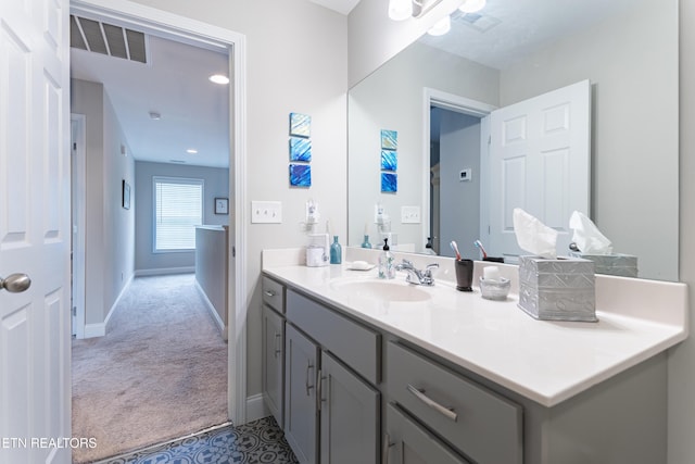 bathroom with baseboards, visible vents, and vanity