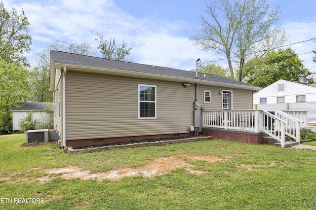 rear view of property featuring a lawn and crawl space