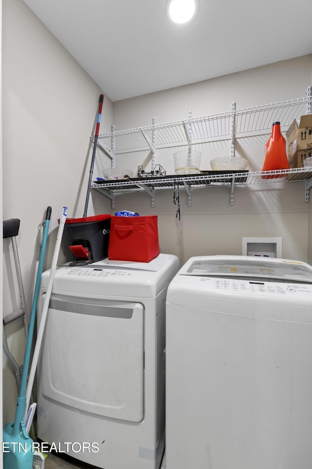 clothes washing area with washer and clothes dryer and laundry area
