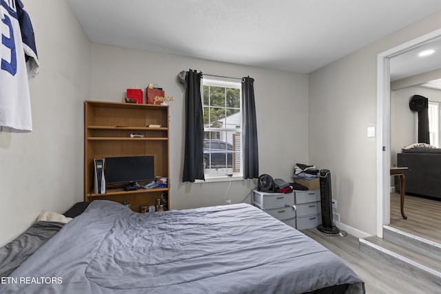 bedroom with wood finished floors and baseboards