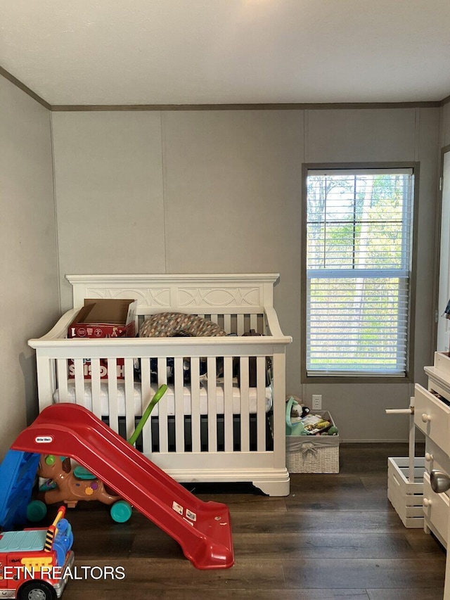 bedroom with wood finished floors and crown molding
