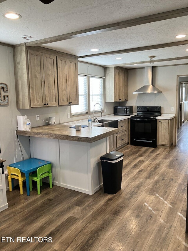 kitchen with dark wood finished floors, a textured ceiling, wall chimney range hood, a sink, and electric range