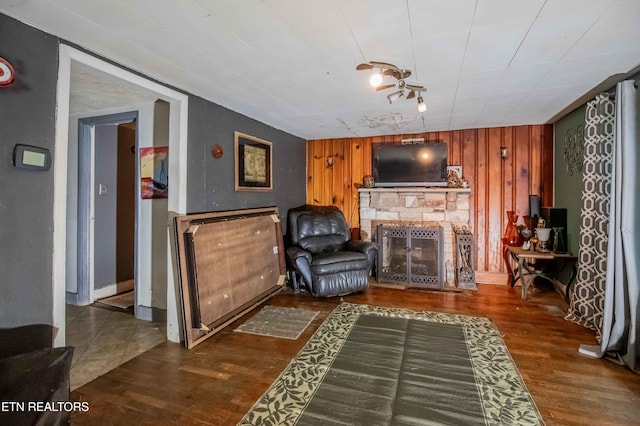 living room featuring wood walls, wood finished floors, and a fireplace