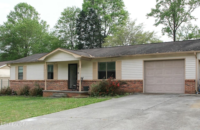 ranch-style home featuring a porch, a front lawn, driveway, and brick siding