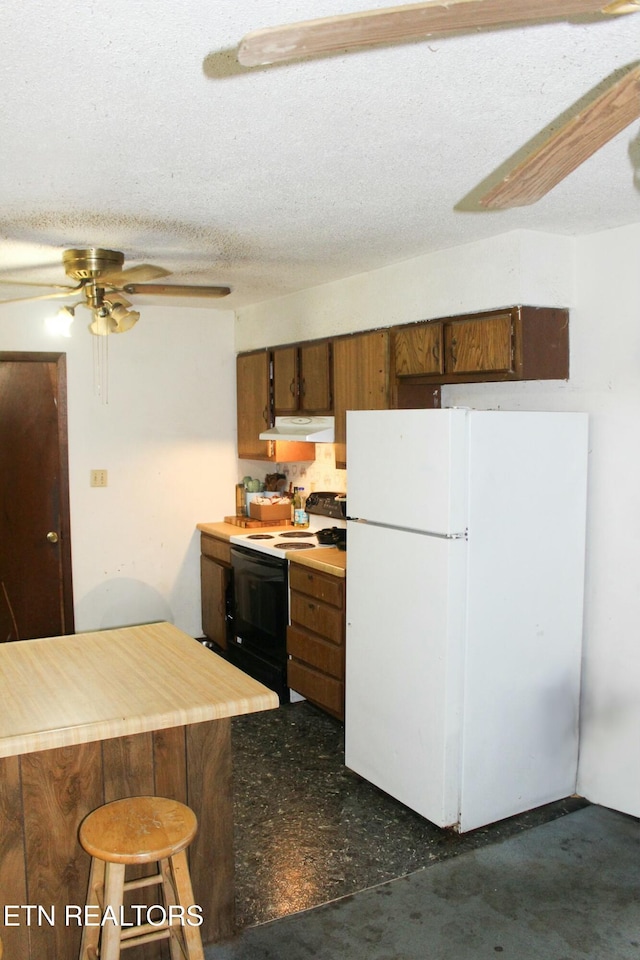 kitchen featuring range hood, a ceiling fan, range with electric stovetop, a textured ceiling, and freestanding refrigerator