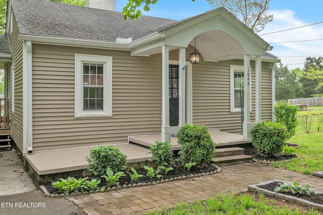 exterior space with a shingled roof and a chimney