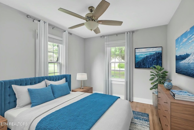 bedroom featuring wood finished floors, a ceiling fan, and baseboards