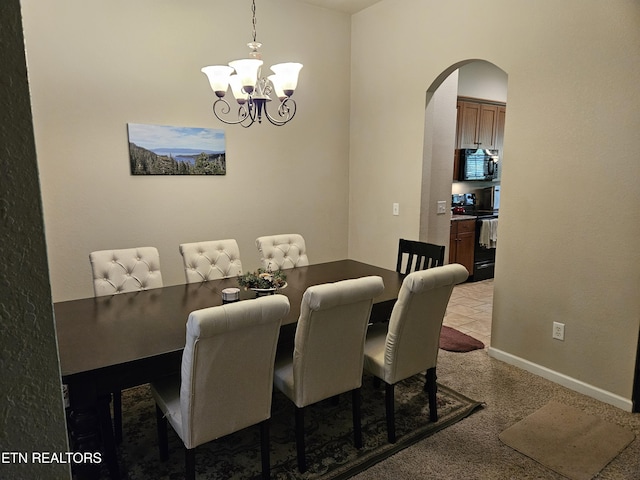 dining area featuring baseboards, arched walkways, and an inviting chandelier